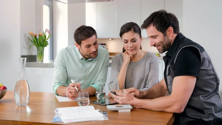 Installateur berät ein junges Paar zum Erneuern ihrer Gasheizung