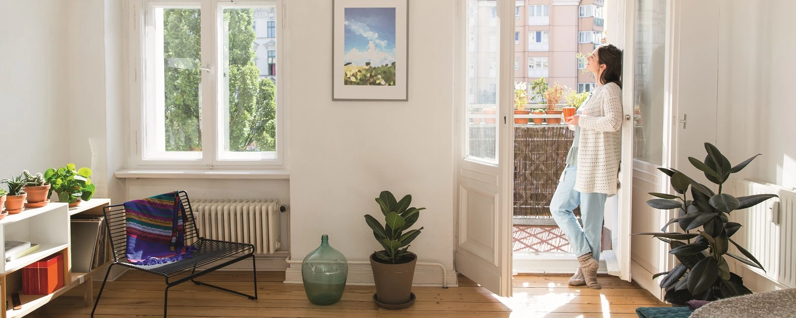 Frau steht an offener Balkontür