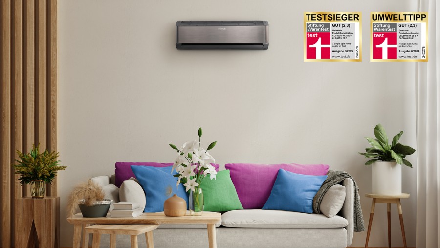 Ein beiges Sofa steht in einem Raum mit vielen bunten Kissen und darüber hängt eine Klimaanlage an der Wand. Rechts danaben sind Textsieger Logos zu sehen. Ein beiges Sofa steht in einem Raum mit vielen bunten Kissen und darüber hängt eine Klimaanlage an der Wand. Rechts danaben sind Textsieger Logos zu sehen.