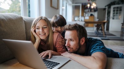 Familie liegt mit Laptop auf dem Sofa. Familie liegt mit Laptop auf dem Sofa.
