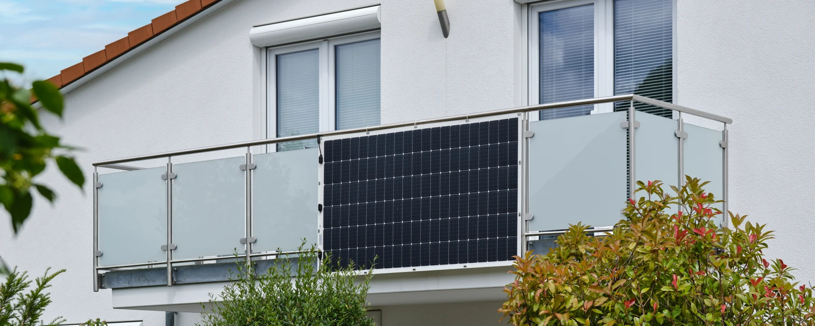An einem Balkon ist eine Solaranlage montiert.