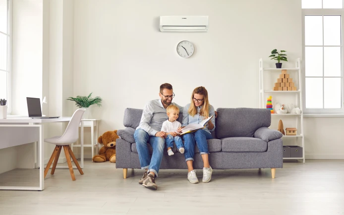 Familie sitzt auf dem Sofa und der Climate 600i hängt an der Wand.