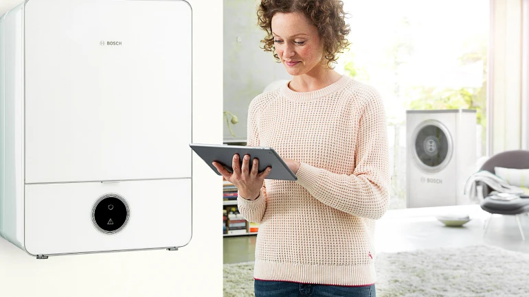 Eine Frau informiert sich am Tablet über die Kosten einer Luftwärmepumpe.