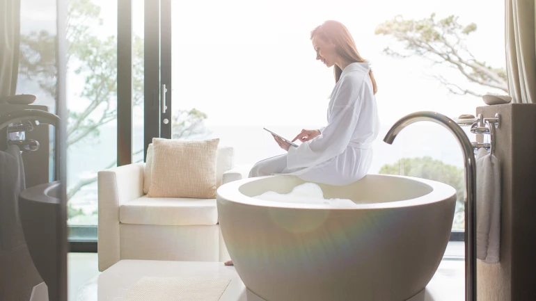 Frau informiert sich über neue effiziente Warmwasserbereitung von Bosch, um Heizkosten zu sparen