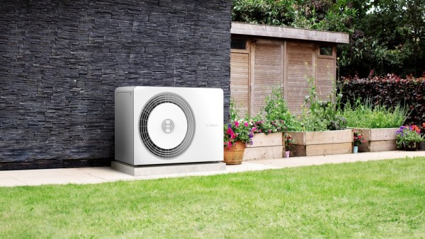 Wärmepumpe steht an Hauswand im Garten