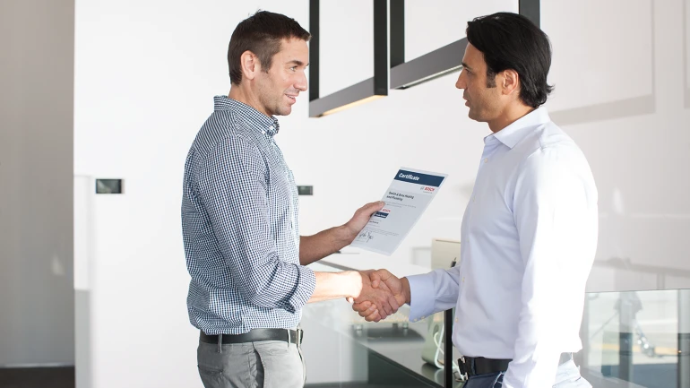 Zwei Männer in Hemden geben sich die Hand