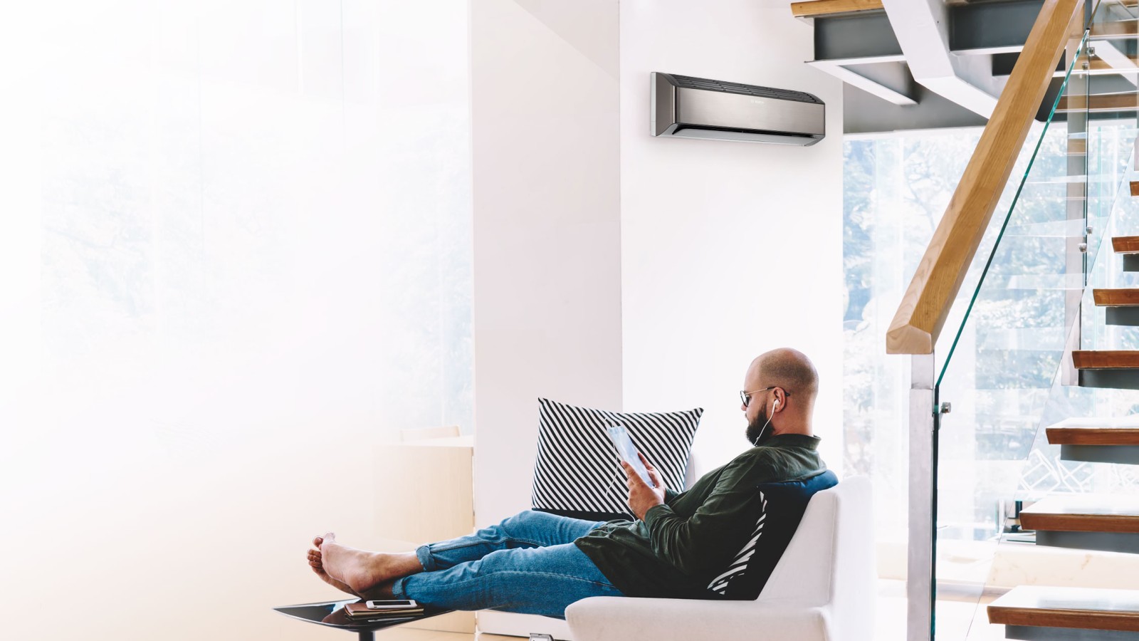 Ein Mann entspannt in seinem Sessel und genießt den komfortablen, energiesparenden Betrieb dank modernster Inverter-Technologie. Das ist der Climate Class 8000i. Ein Mann entspannt in seinem Sessel und genießt den komfortablen, energiesparenden Betrieb dank modernster Inverter-Technologie. Das ist der Climate Class 8000i.