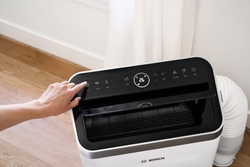 Eine Frau bedient das mobile Klimagerät Cool 5000 von Bosch in einer Nahaufnahme.
