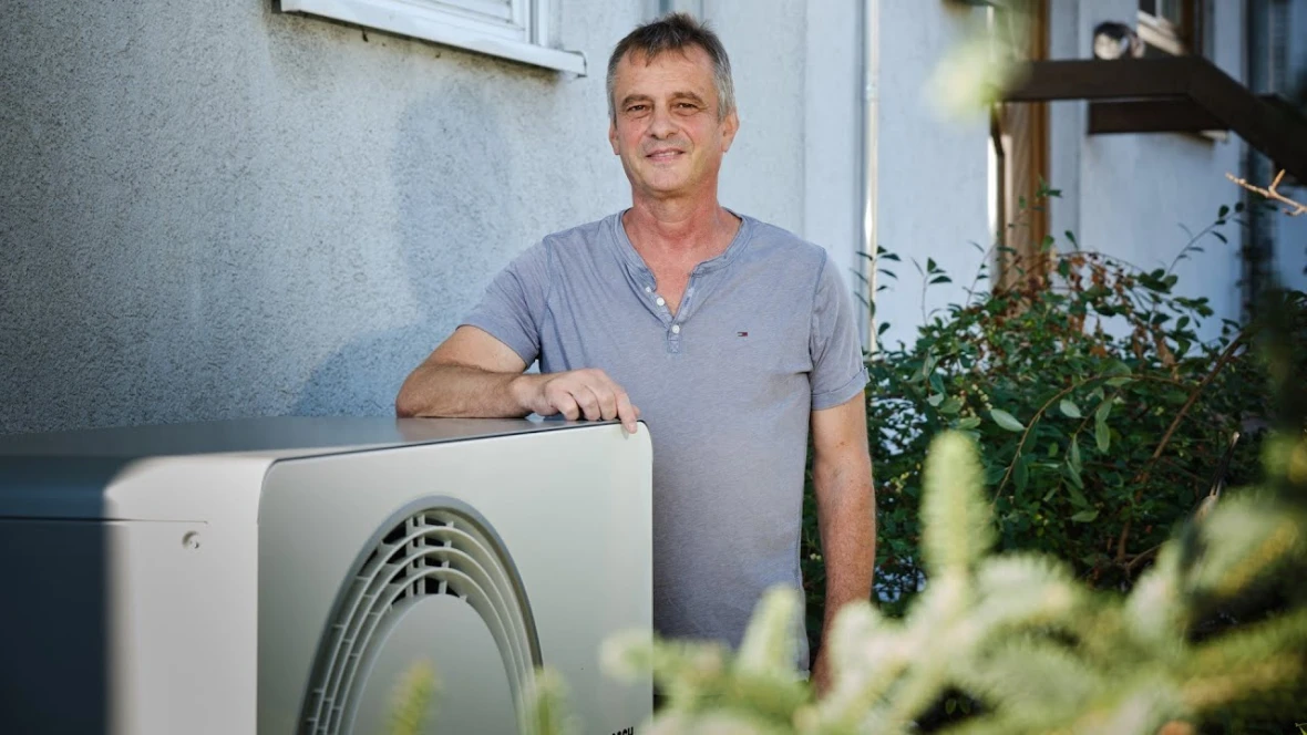 Mann steht vor Wärmepumpe Compress 6800i AW von Bosch