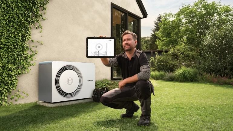 Installer in front of heat pump Install Like a Bosch