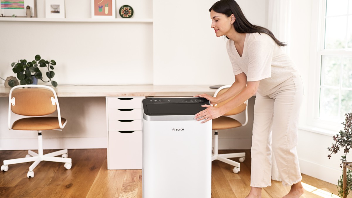 Woman moves portable air conditioner Cool 4000 in office area Woman moves portable air conditioner Cool 4000 in office area