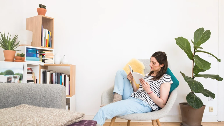 Mujer leyendo un libro en una silla