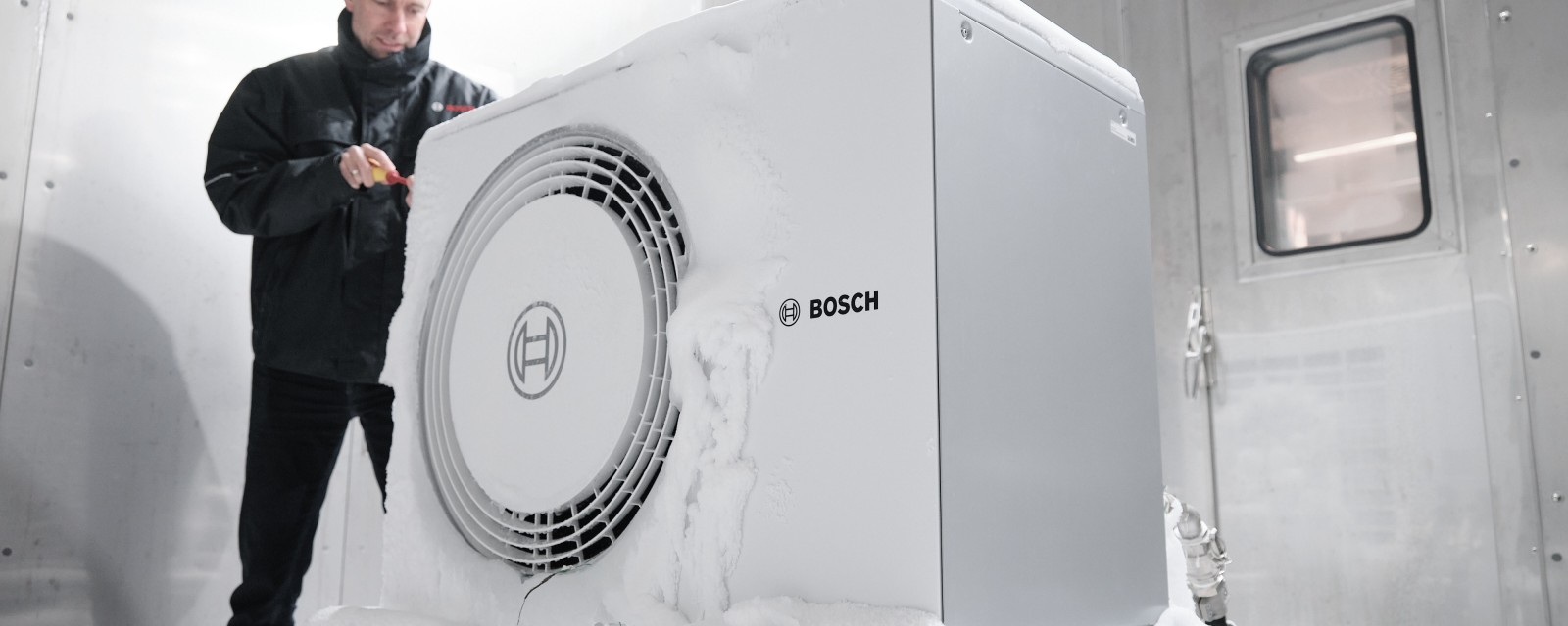 Installateur avec une pompe à chaleur Bosch dans le froid Installateur avec une pompe à chaleur Bosch dans le froid