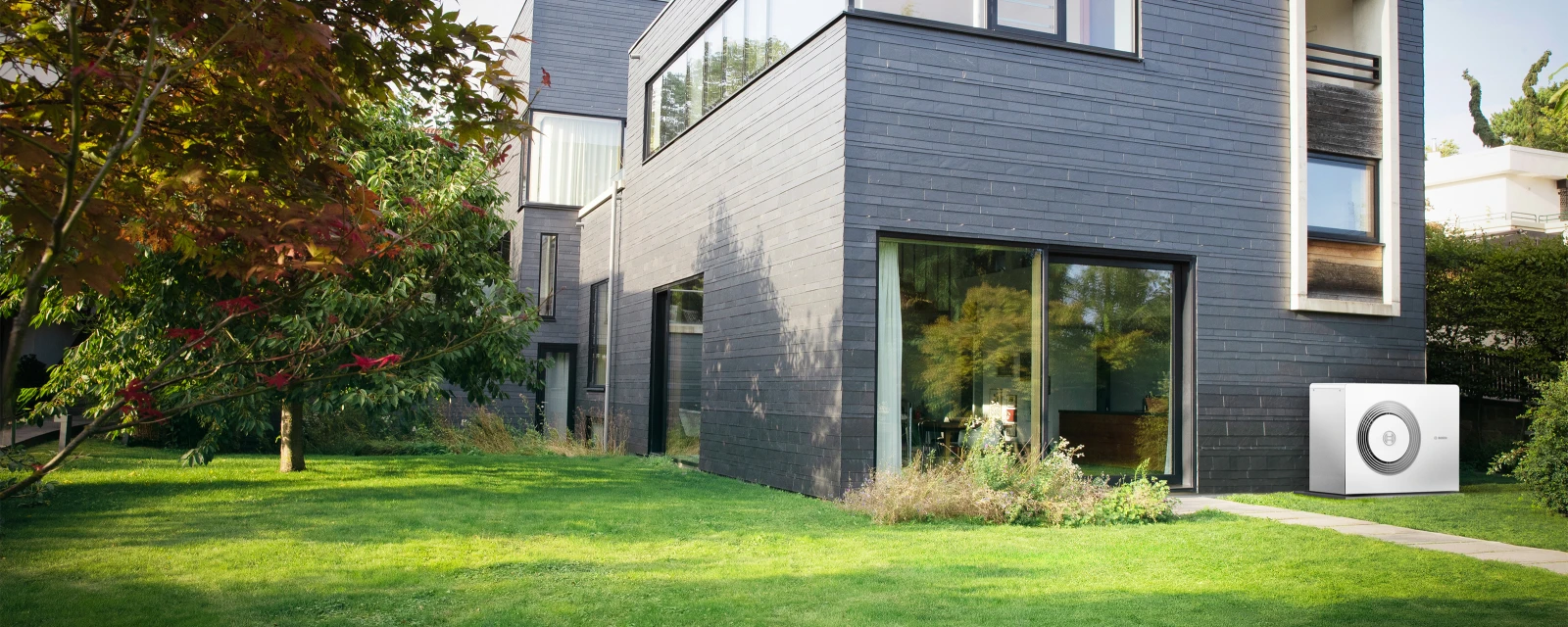 La pompe à chaleur Compress 5800i AW Bosch est montée sur le mur d'une maison individuelle.