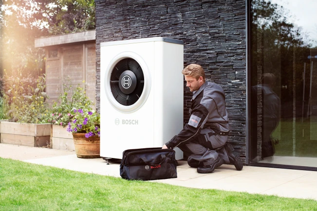 Un installateur installe une pompe à chaleur