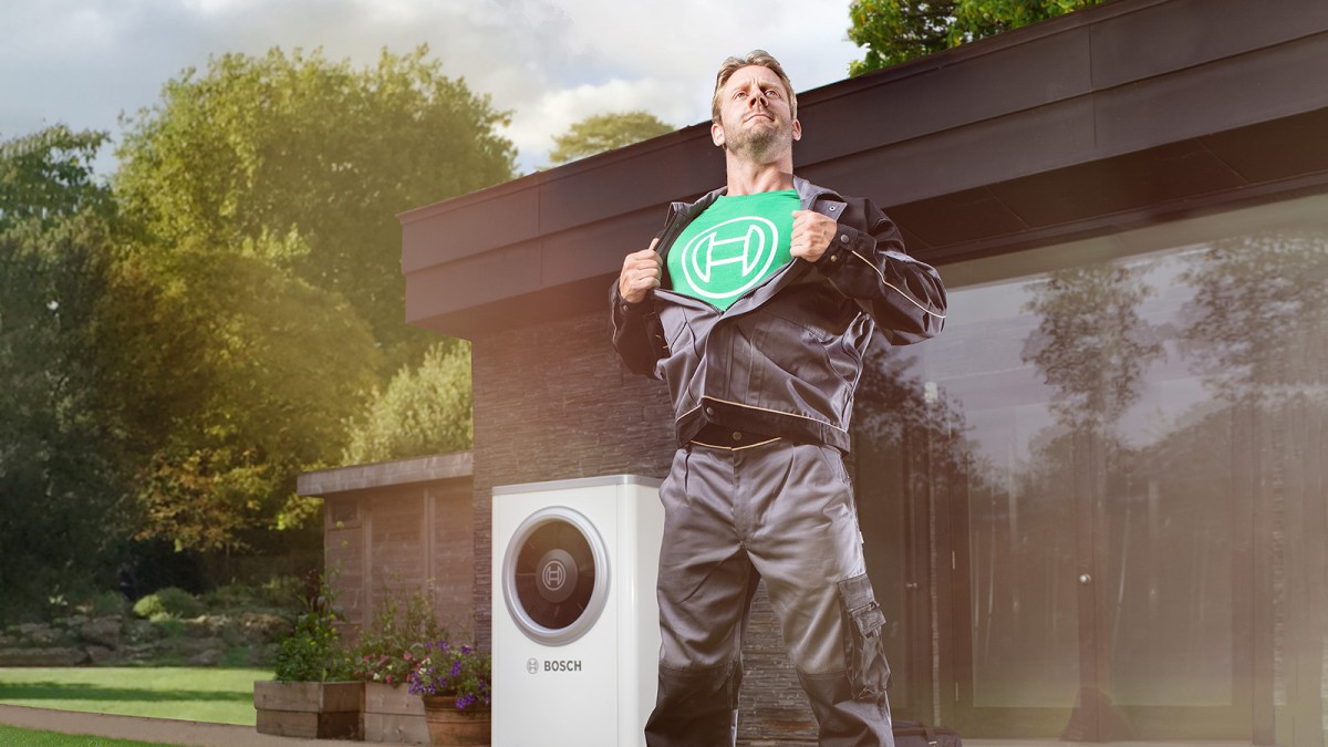 Un installateur Bosch devant une pompe à chaleur Bosch Un installateur Bosch devant une pompe à chaleur Bosch