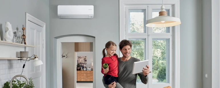 Père avec son enfant regardant une tablette avec une climatisation Bosch