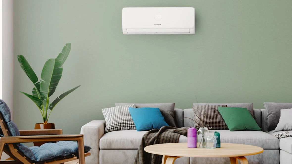 Weiße Klimaanlage Bosch Climate 3200i an der Wand eines modern eingerichteten Wohnzimmers