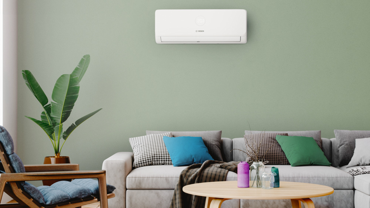 Weiße Klimaanlage Bosch Climate 3200i an der Wand eines modern eingerichteten Wohnzimmers