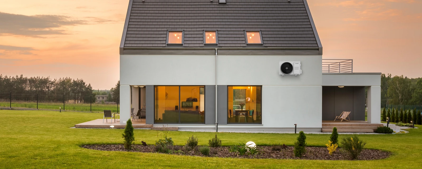 New building with a terrace and surrounded by a lot of green space, on the outer facade the Bosch Climate 3000i outdoor unit