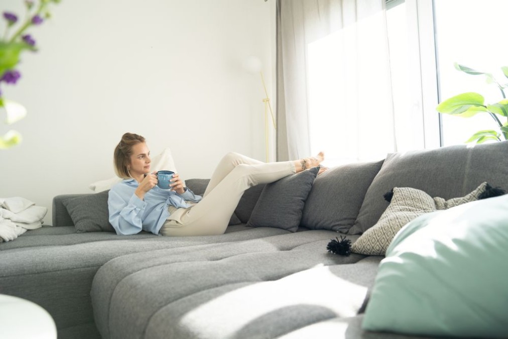 Woman relaxes on couch and enjoys the cool apartment Woman relaxes on couch and enjoys the cool apartment