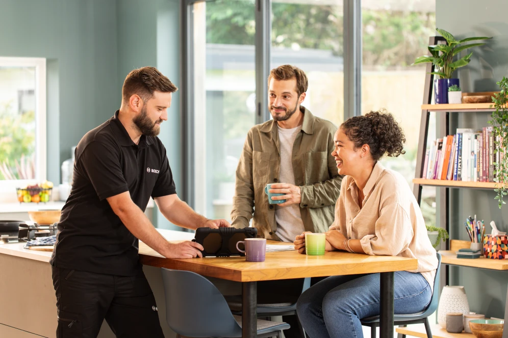 Installer with clients at a table