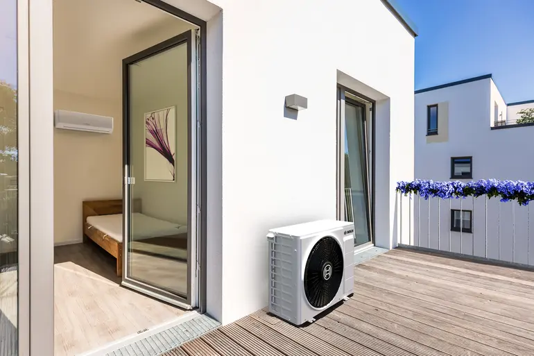 Bosch Climate 7000i Single-Split Klimagerät mit Außeneinheit auf Terrasse und Inneneinheit im Schlafzimmer.