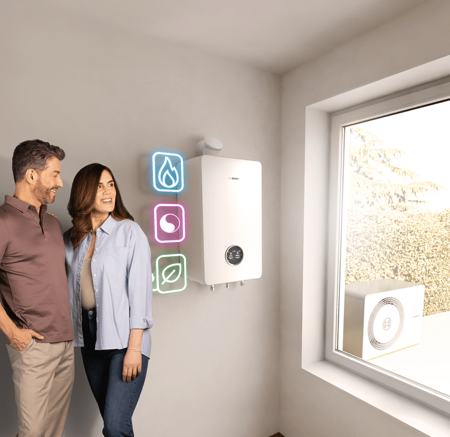 Paar steht vor Bosch All-in-One Heizung Compress Hybrid 5800i G, Icons für Gas, Hybrid und Wärmepumpe leuchten daneben.