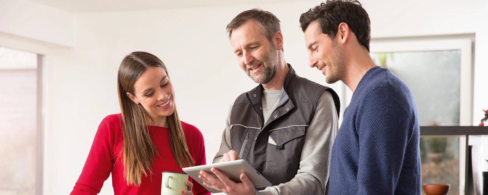A young couple has the cost of a heat pump explained to them by a specialist.