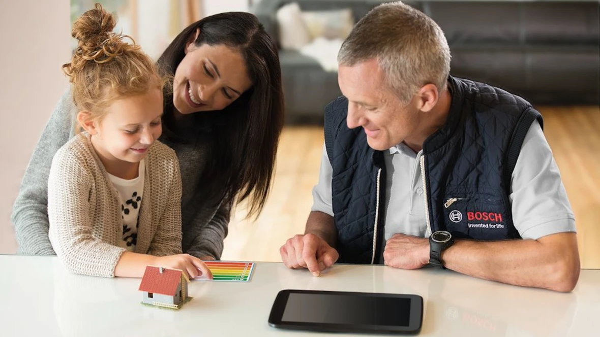 A young woman with a child talks to a Bosch heat pump specialist.