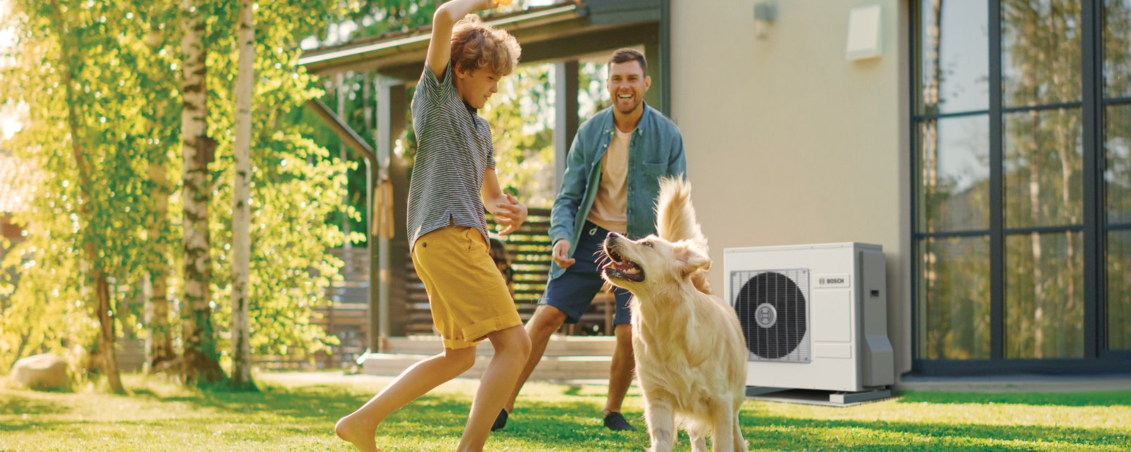 Pai e filho a brincar com o cão no jardim Pai e filho a brincar com o cão no jardim
