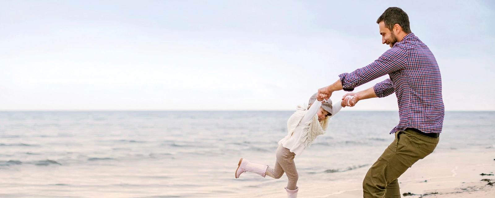 Pai a brincar com o seu filho na praia