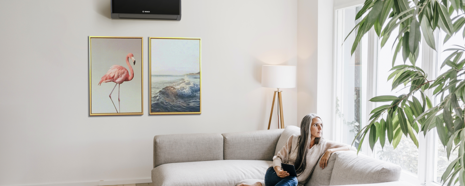 Woman sitting on a couch in front of an air conditioner.
