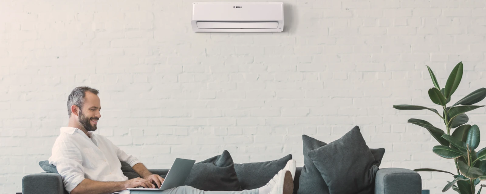 Man sitting on a sofa in front of an air conditioner