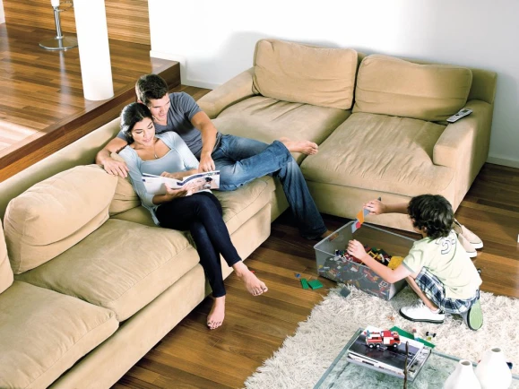 Couple with child is in the living room and enjoys heat from the floor heating system