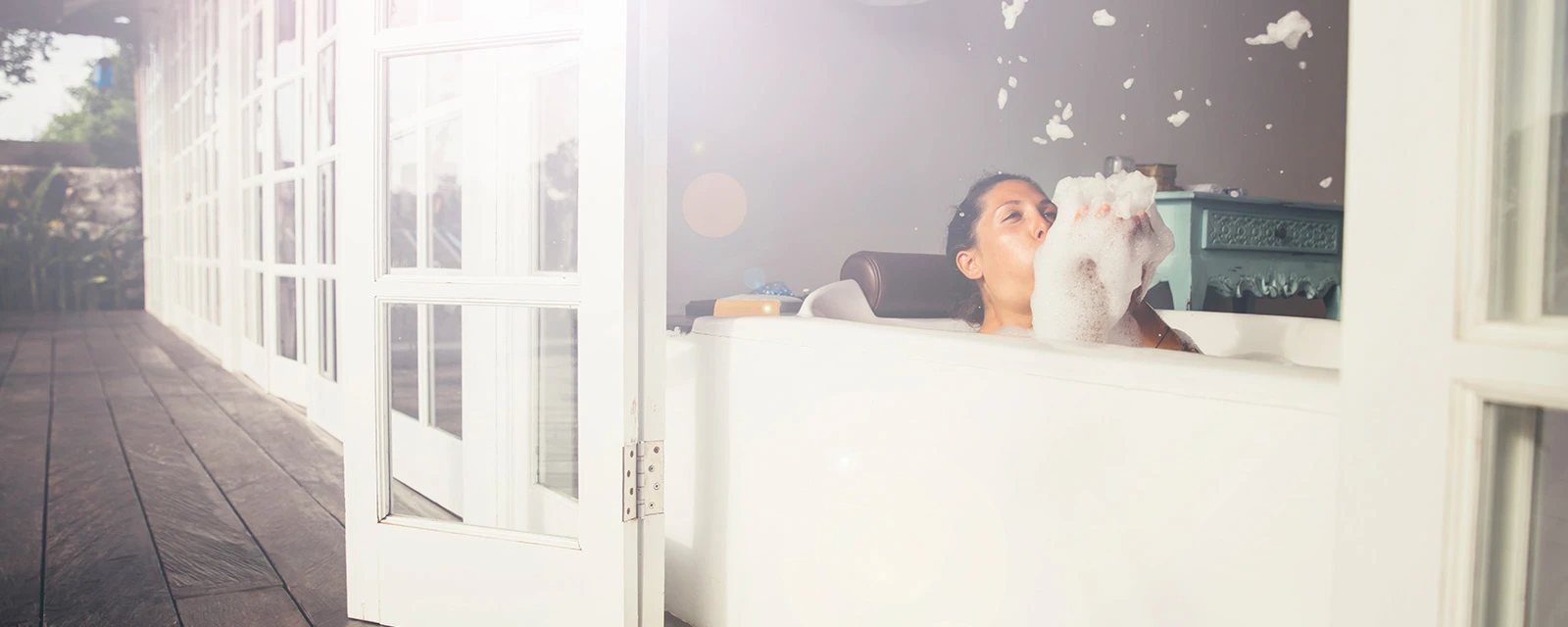woman bathing in a tub with foam in her hands