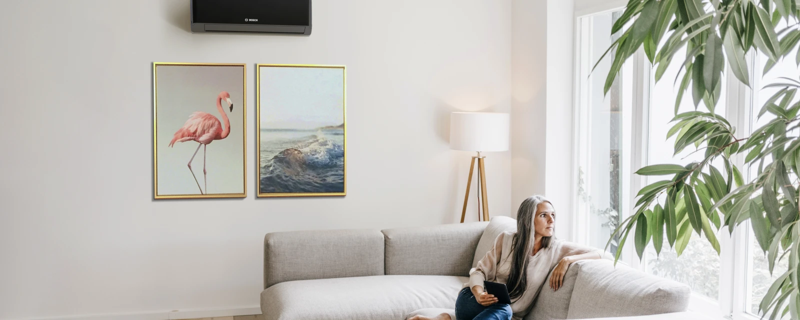 Woman sitting on a couch in front of an air conditioner.