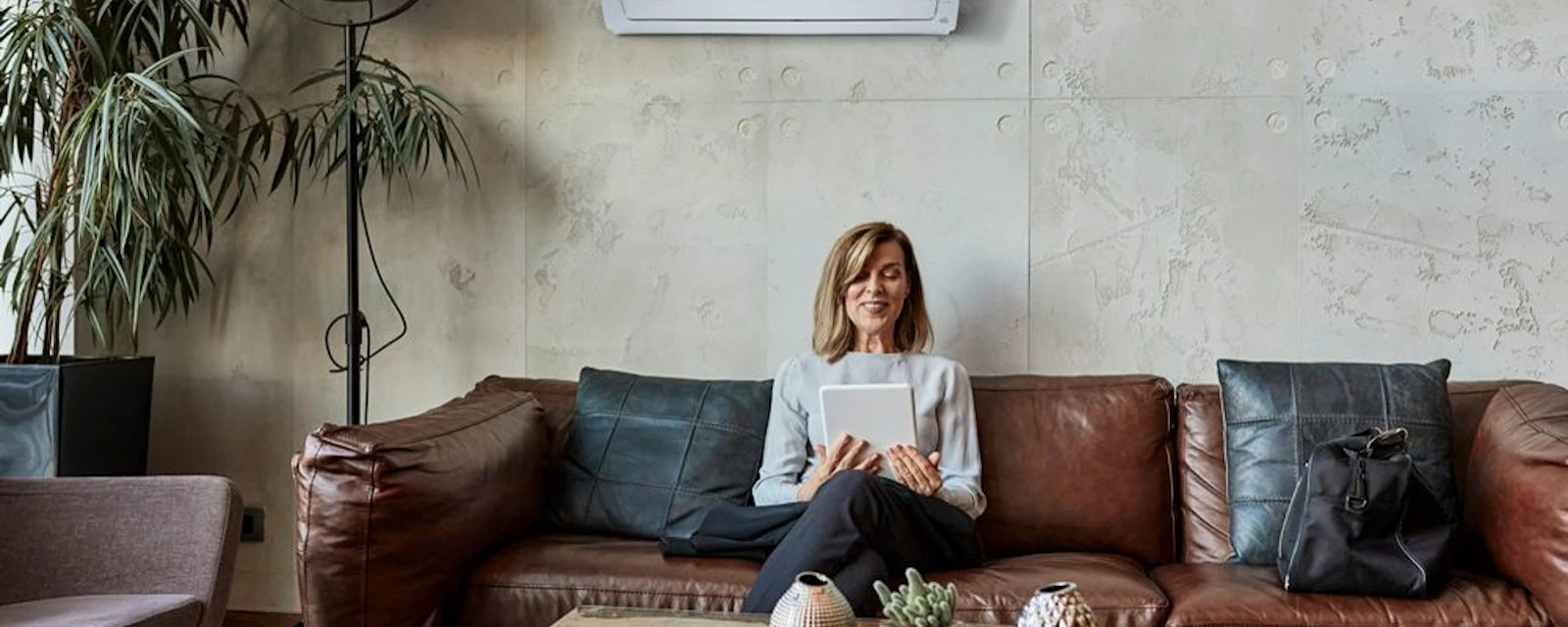 Woman sitting on a sofa in front of an air conditioner