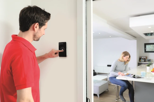 Muž mení nastavenie teploty cez relugátor EasyControl