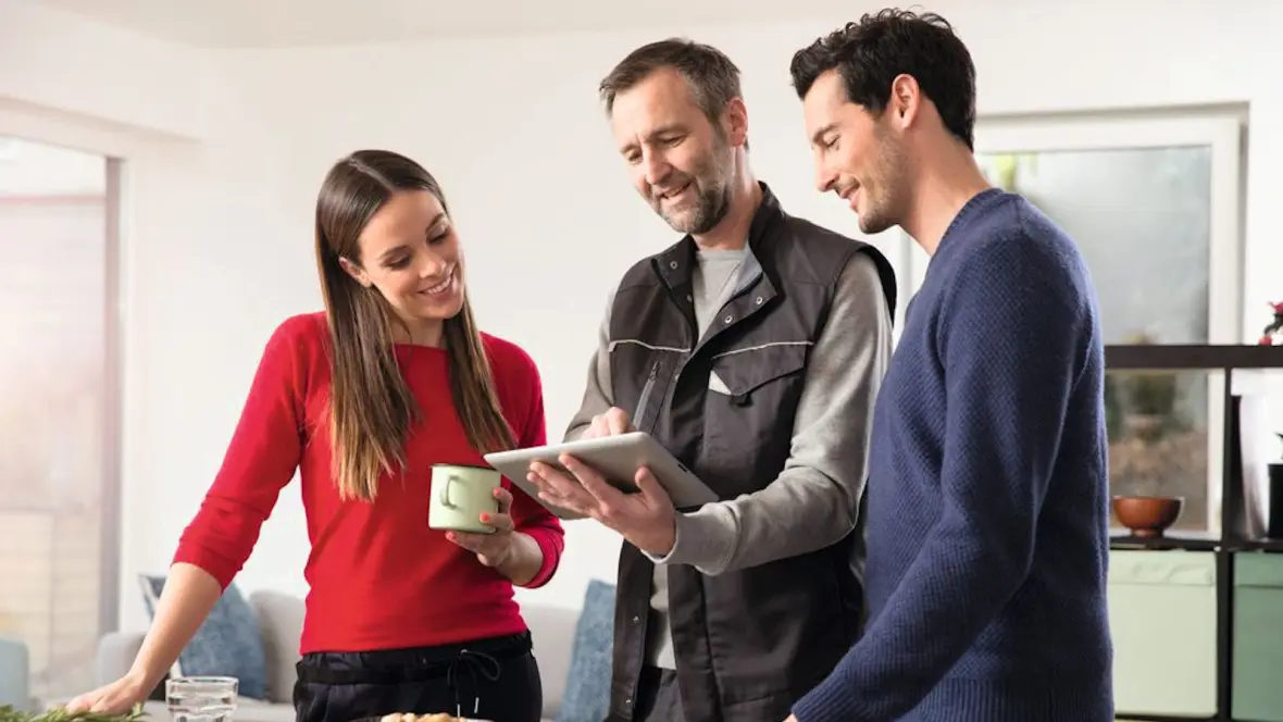 يقدم أحد فنيي التركيب من Bosch نصيحة للعميل الذي يمتلك جهازًا لوحيًا في المطبخ