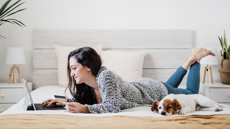 Жінка з собакою на ліжку, на стіні кондиціонер Bosch Climate