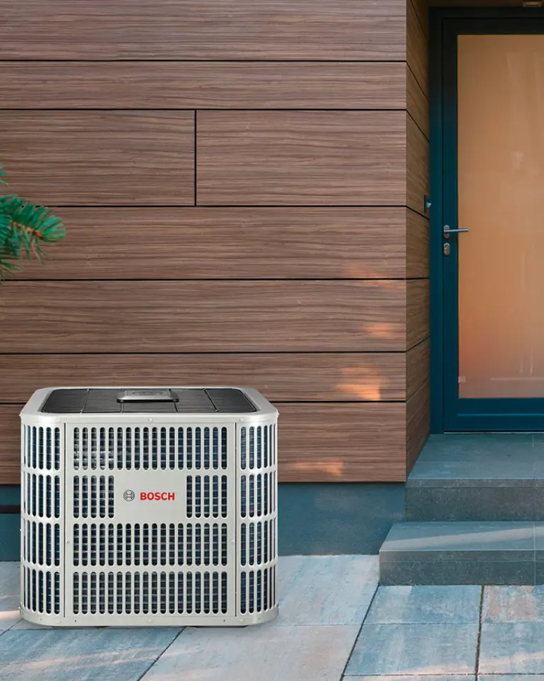 Bosch installer standing next to IDS heat pump